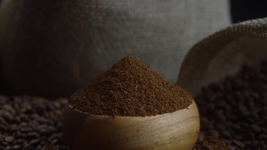 Ground coffee falls into a bowl