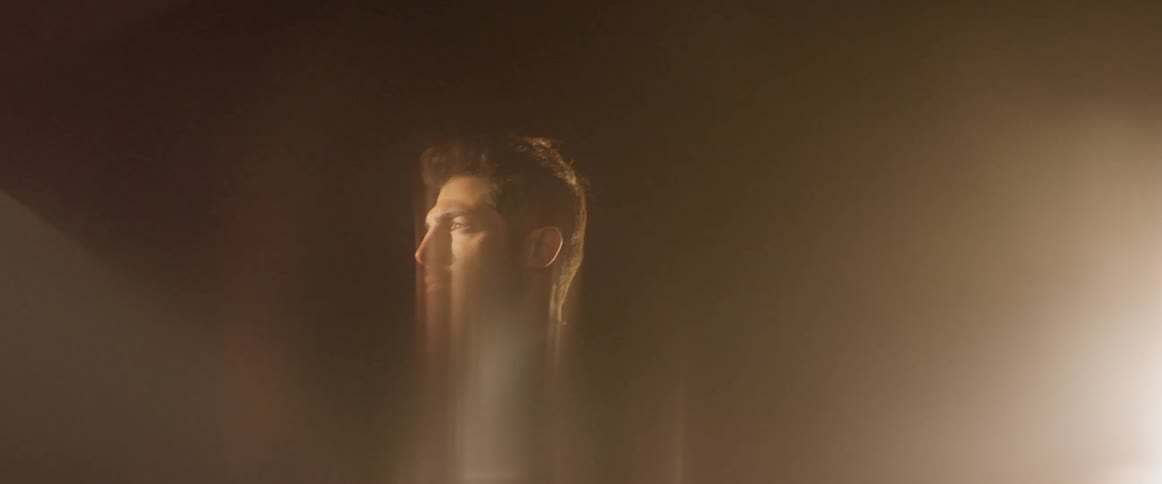 A man stands in a brightly lit room