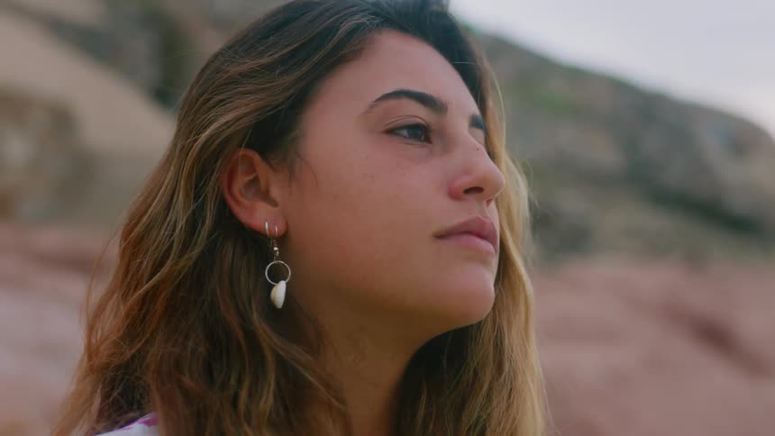 A woman pushes her hair behind her ear