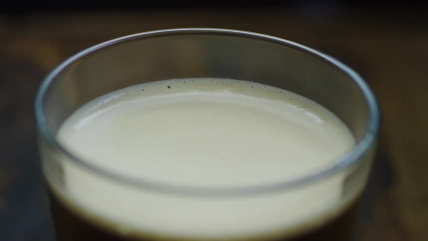 A glass of beer sits on a table
