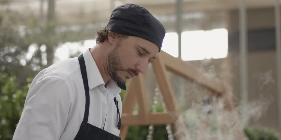 Steam rises up in front of a man wearing an apron