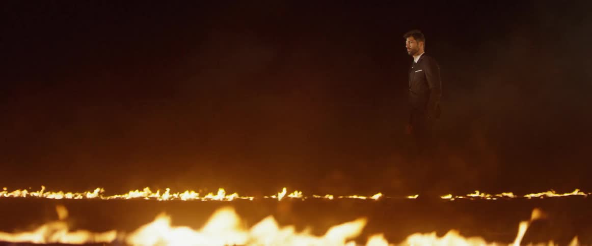 Man walks by fire burning on the ground