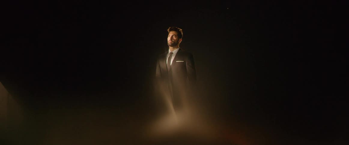 A light shines on a man in a suit