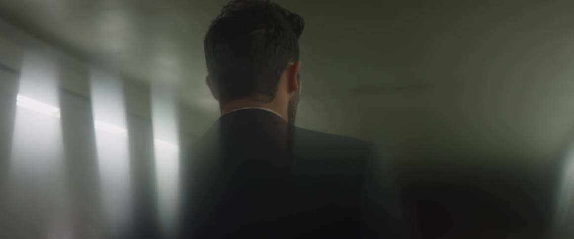 A man in a suit is walking in a parking garage