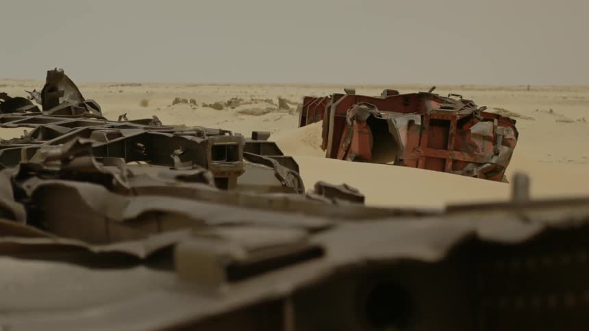 Metal wreckage is lying dormant in the desert during the day
