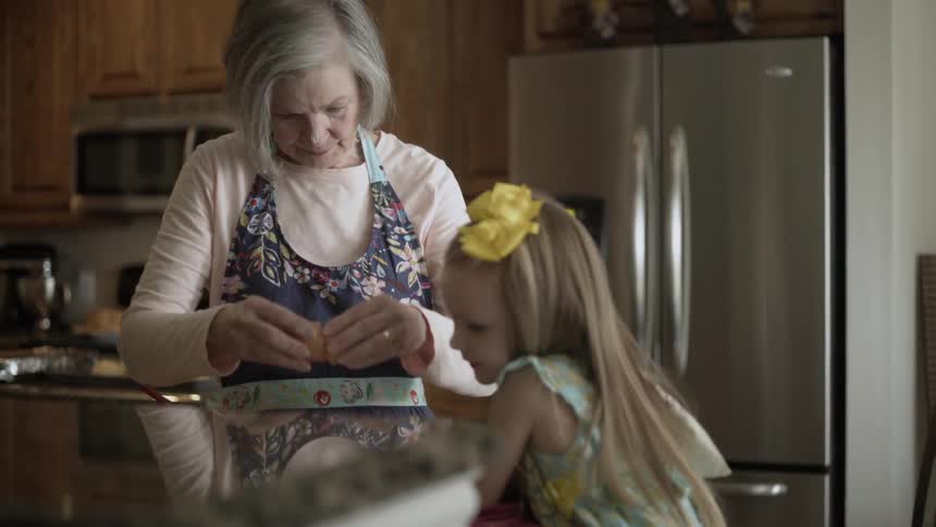 A woman is teaching a child how to cook