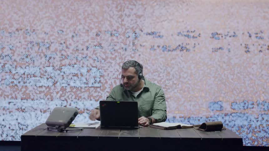 A man works in front of LED wall