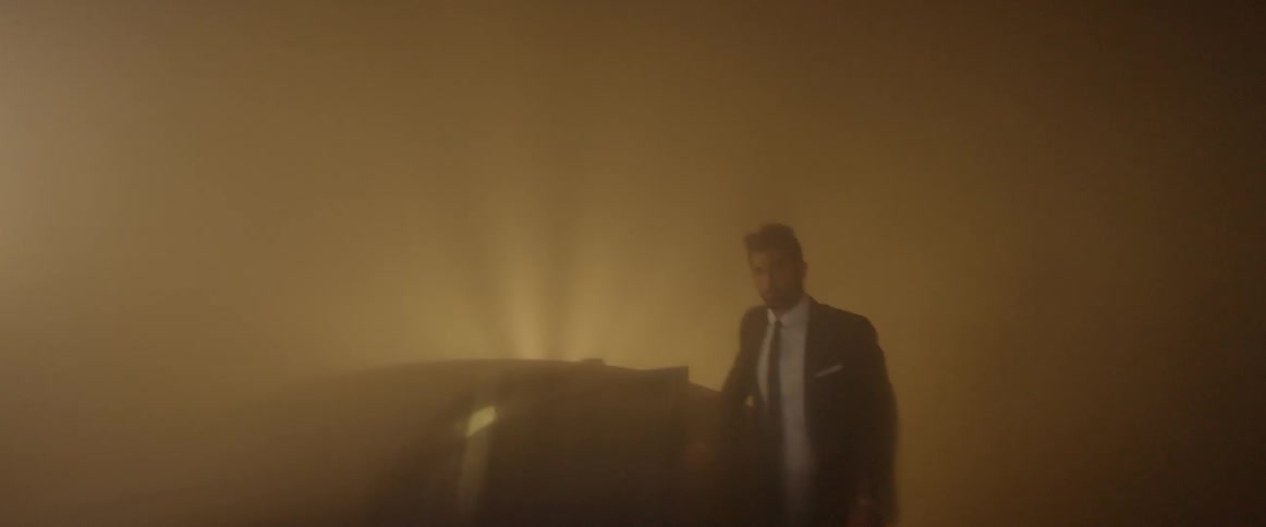 A man exits his car into a smoky area