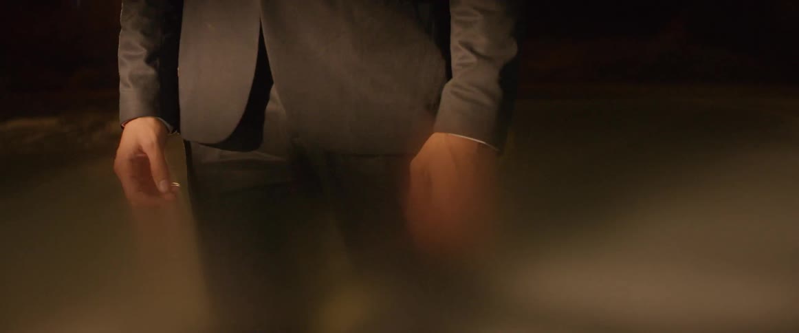 Man in a suit stands in a parking garage