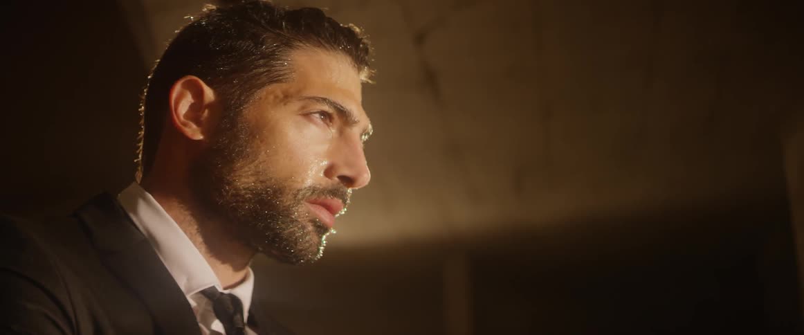 A man in a suit appears to be sweating