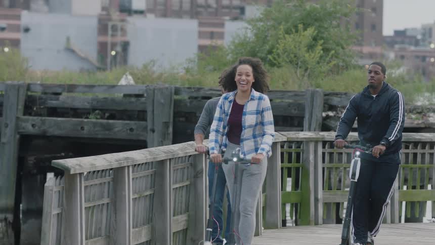 People have fun riding their scooters on the pier
