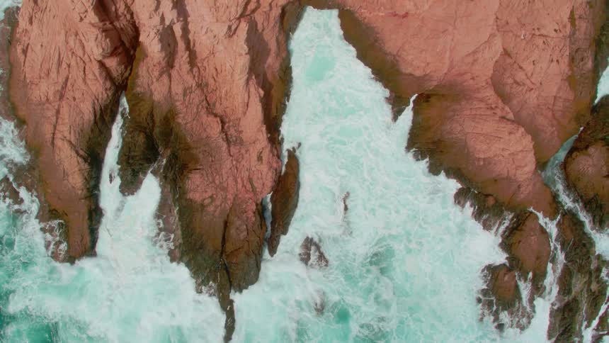 Ocean waves splash and break against the rocks