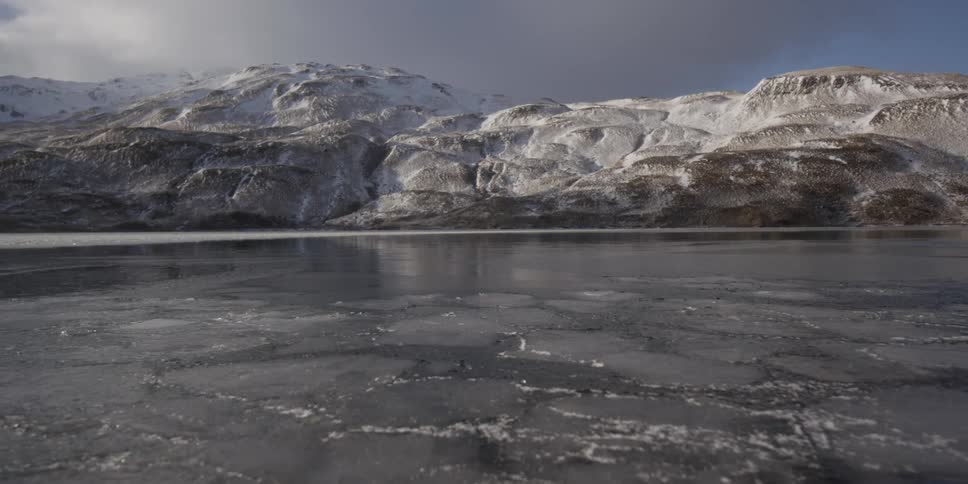 A mountain lake is covered with ice