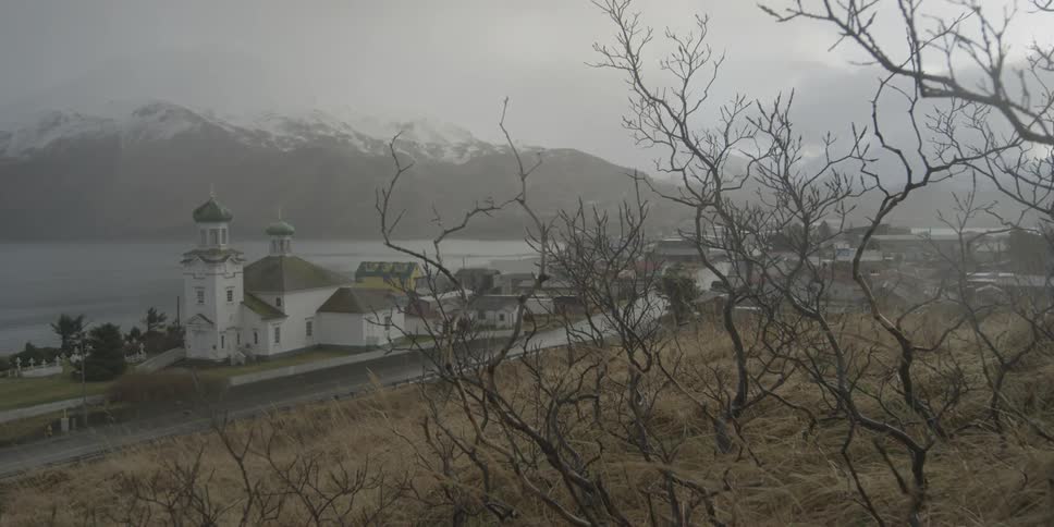 A church and village sit on the shore on a cloudy winter day