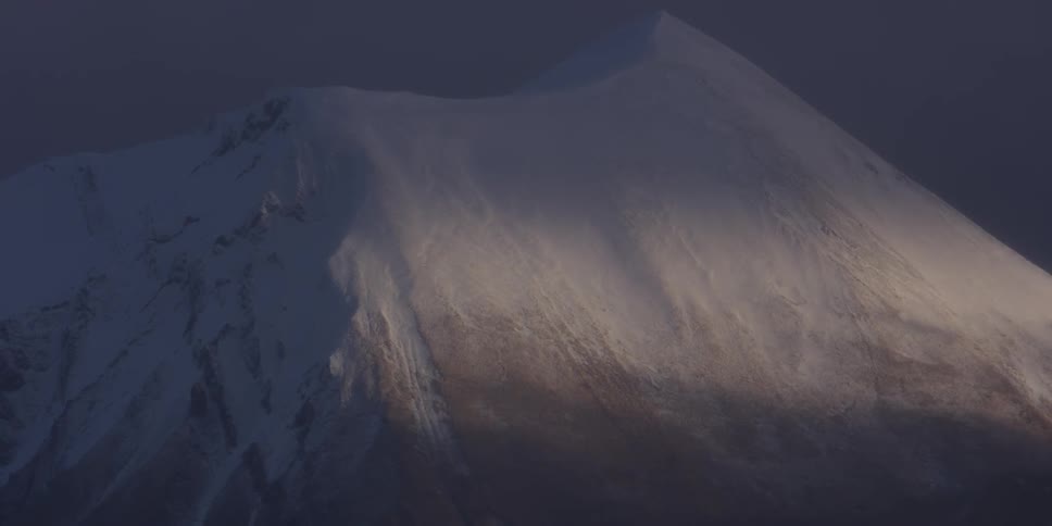 The tall mountain is covered with ice