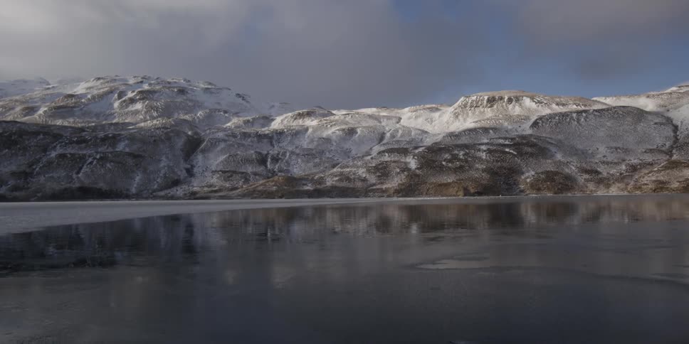 A lake at the base of a snowy mountain
