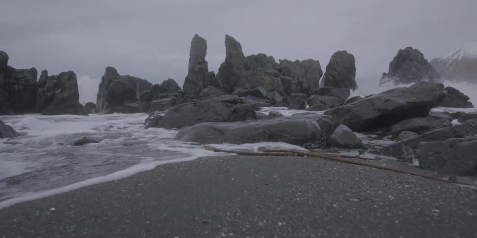 Ocean waves wash ashore a rocky beach