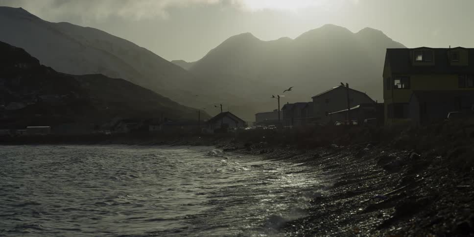 Waves are coming ashore next to a small town