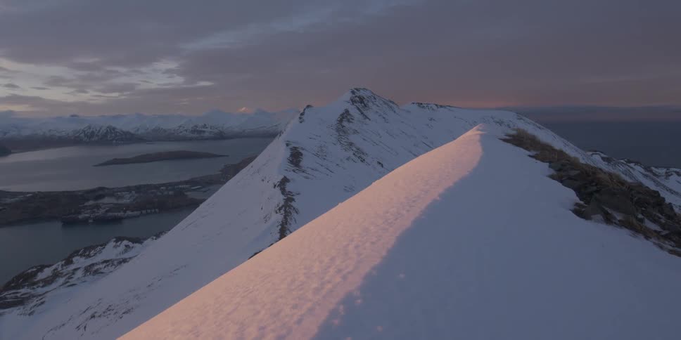 The tall mountains are covered with snow at dawn