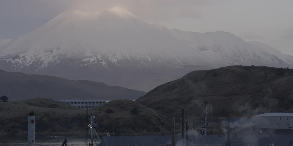 Past the building is a tall snow covered mountain
