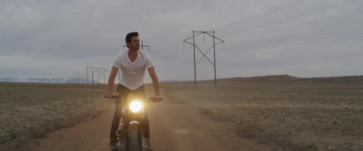 A man rides his motorcycle on the dirt trail