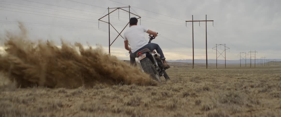 A man turns sharply in the sand on his motorcycle