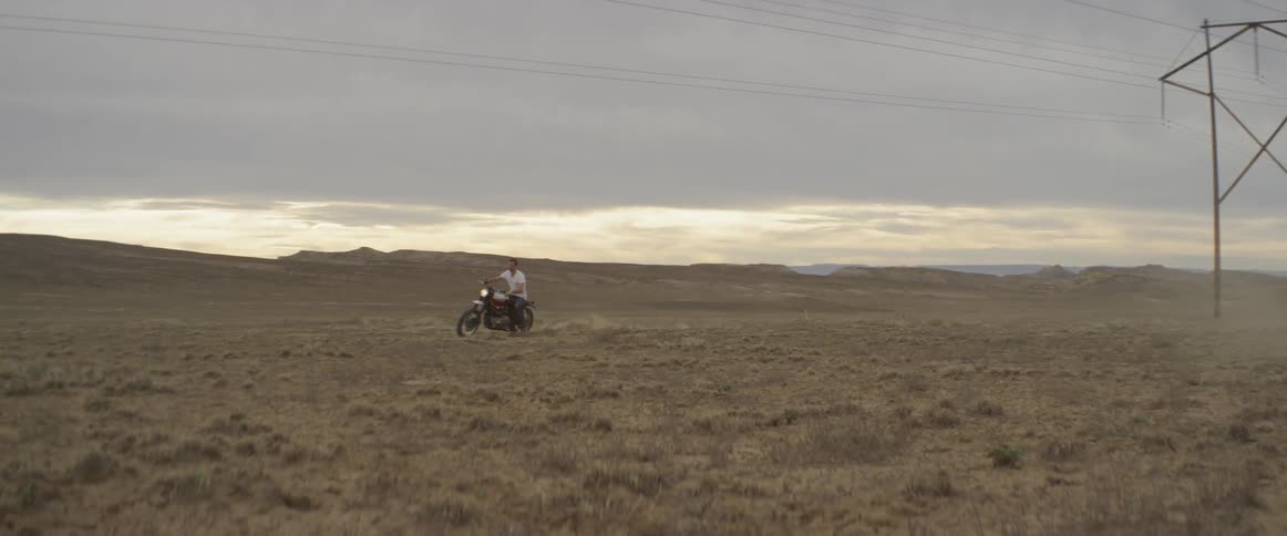 A man is riding his motorcycle on the field