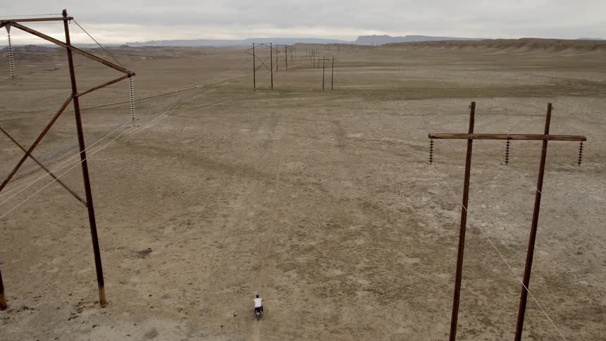 A motorcyclist rides across a rural field
