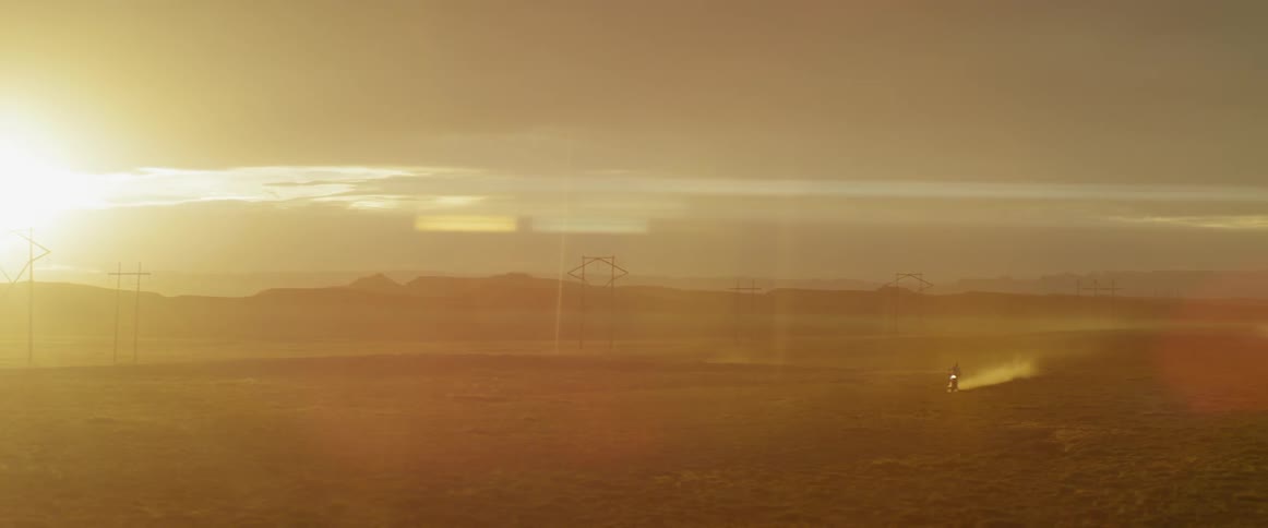 Motorcyclist riding on a sandy desert on a sunny day
