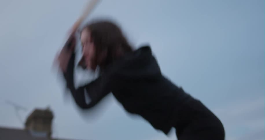Woman smashes a car with a baseball bat