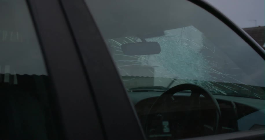 A baseball bat smashes a car windshield