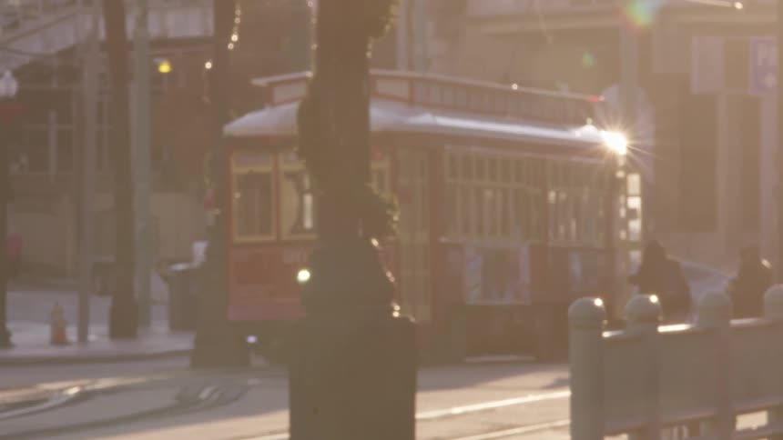 A person approaches the open door of a trolley on a sunny day