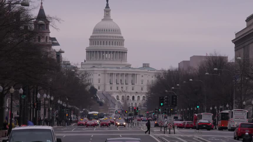 Cars travel on the street near the capitol building