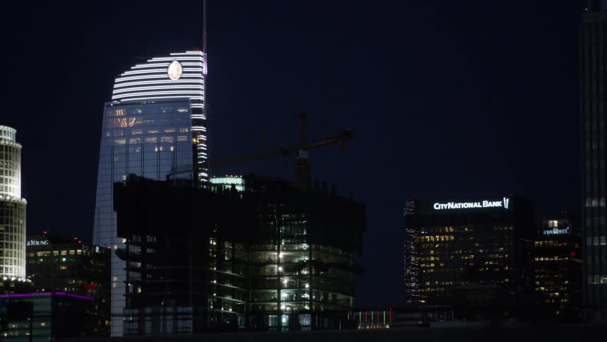 The tall buildings in the city are brightly lit at night