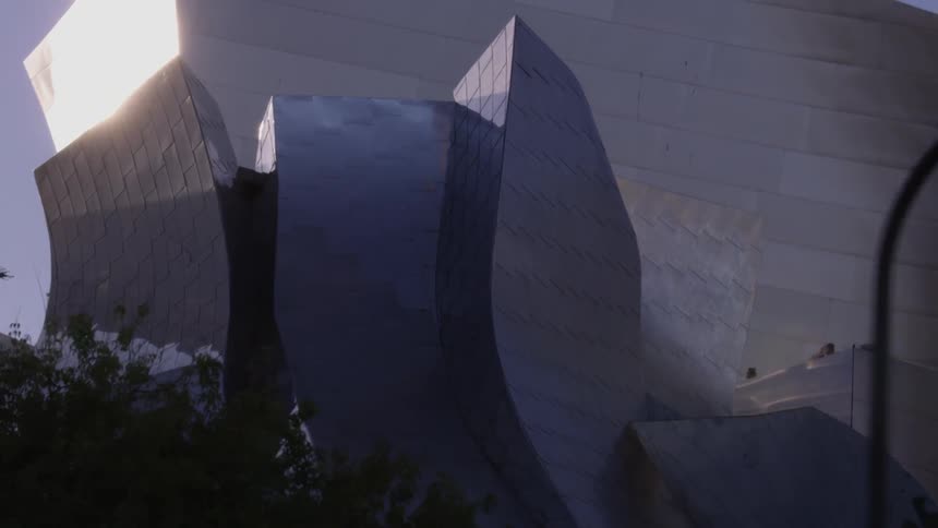 The tall metal sculpture has birds at the top