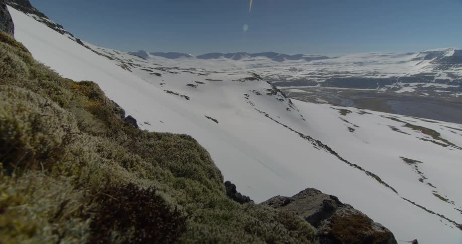 A skier speeds down a snowy mountainside