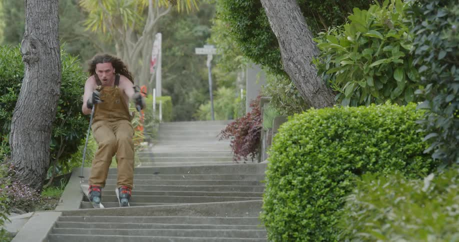 Man is skiing down an outside flight of stairs