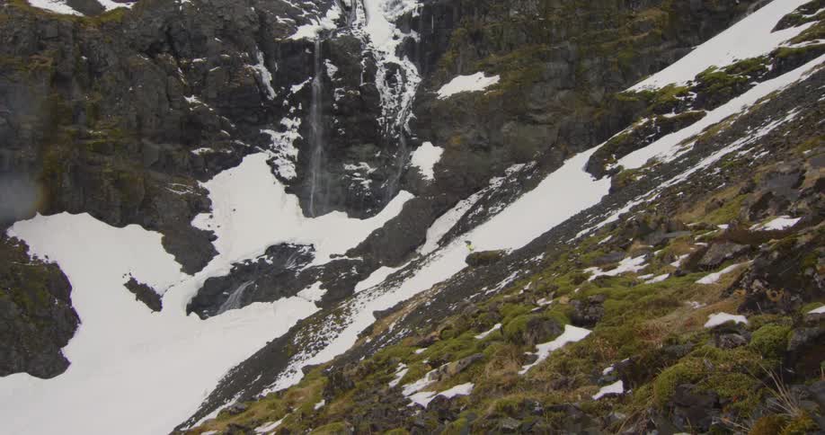 A person skis down a rocky mountain slope