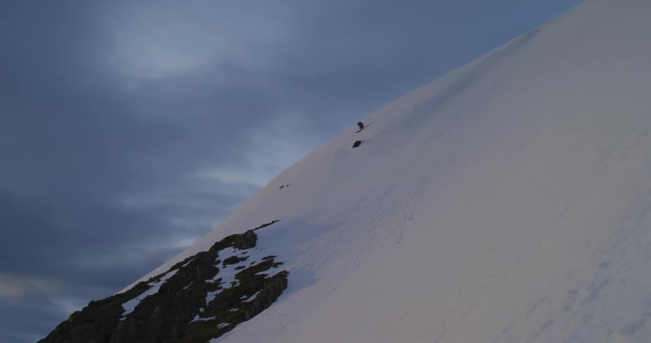 People are skiing down from the top of the mountain