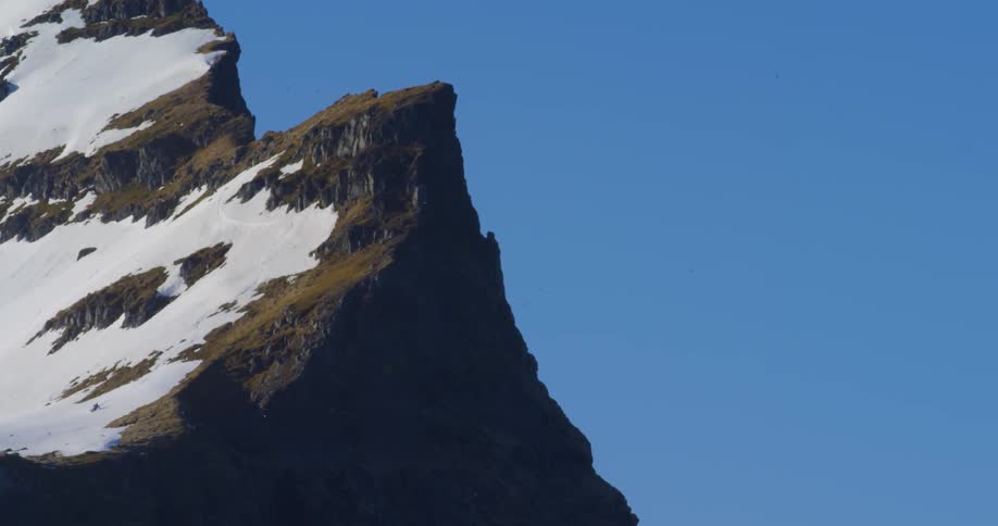 Someone is skiing along the edge of a tall mountain