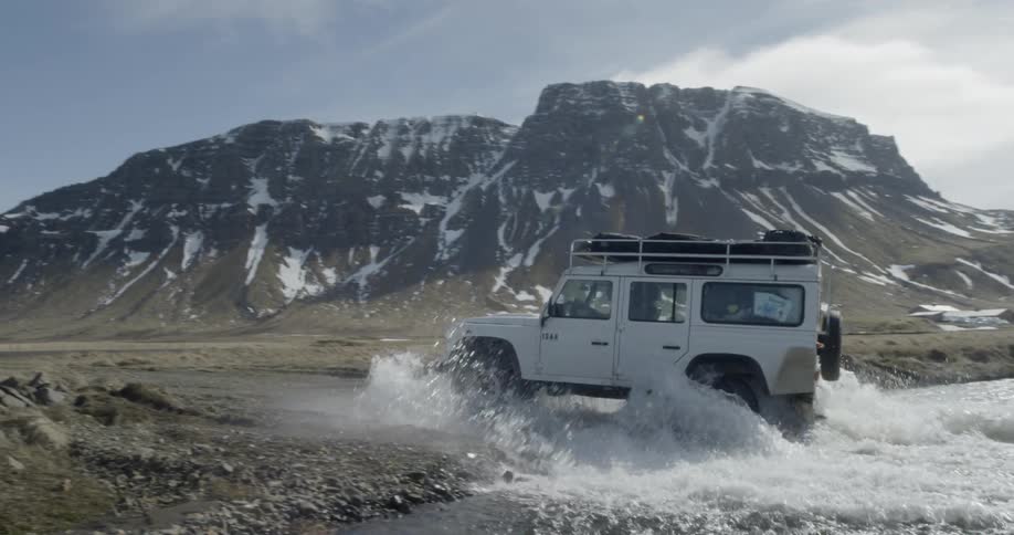 An car drives across a river