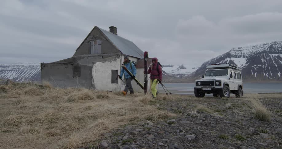 People walking away from a vehicle by old house