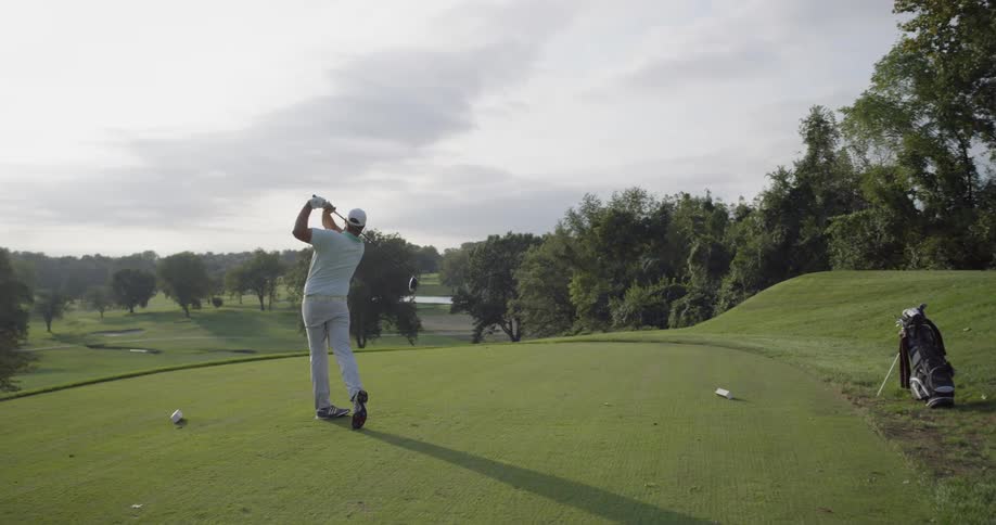 A golfer drives a ball at the course