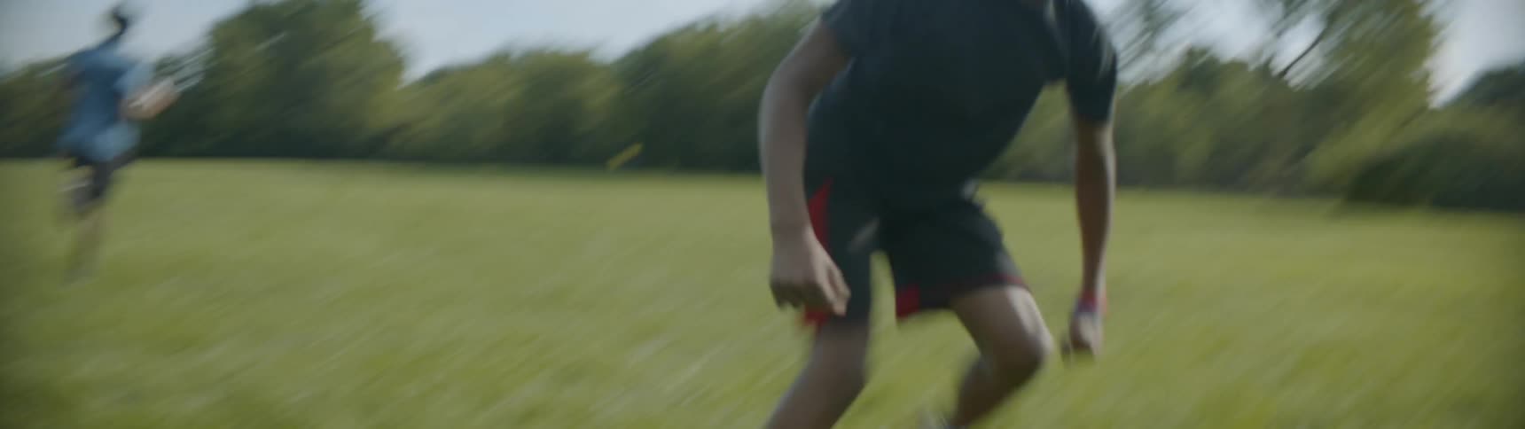 Two young men practice football outside