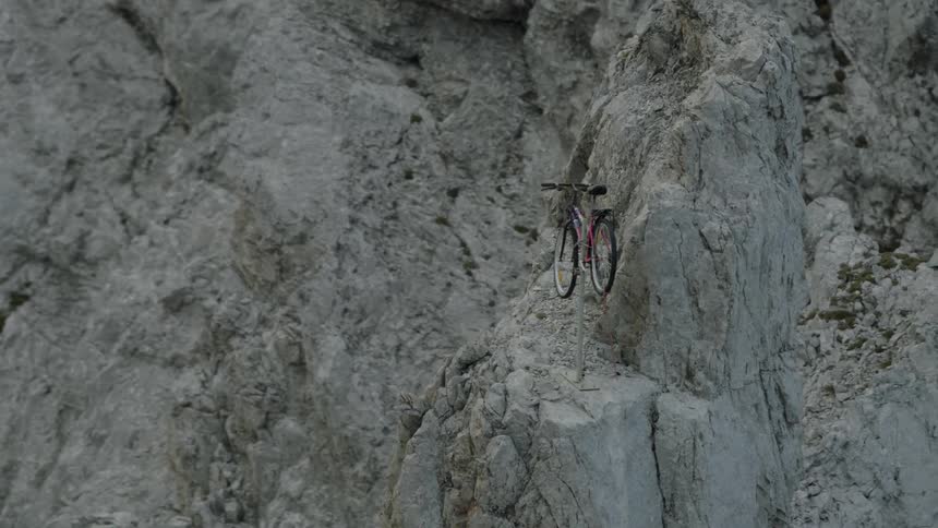 A bicycle is set on top of a high peak on a mountain
