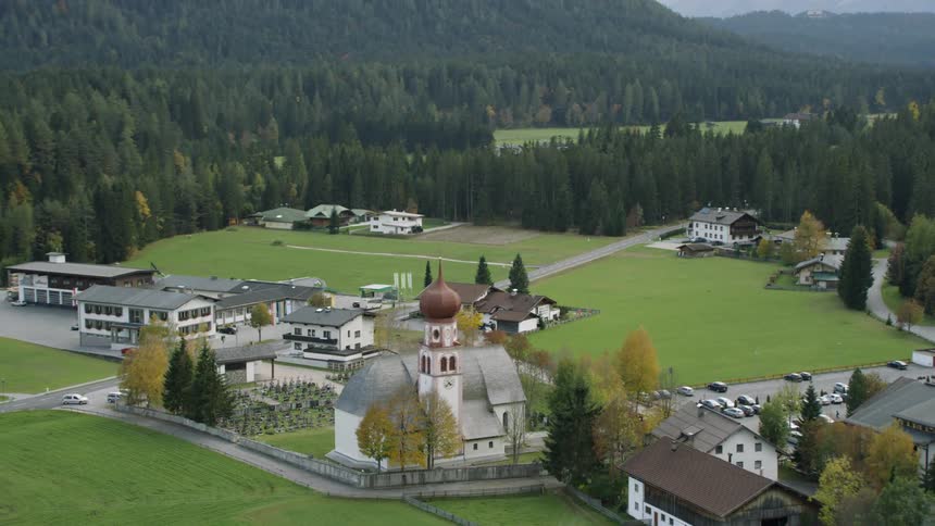 Many buildings that make up a small village near the mountains