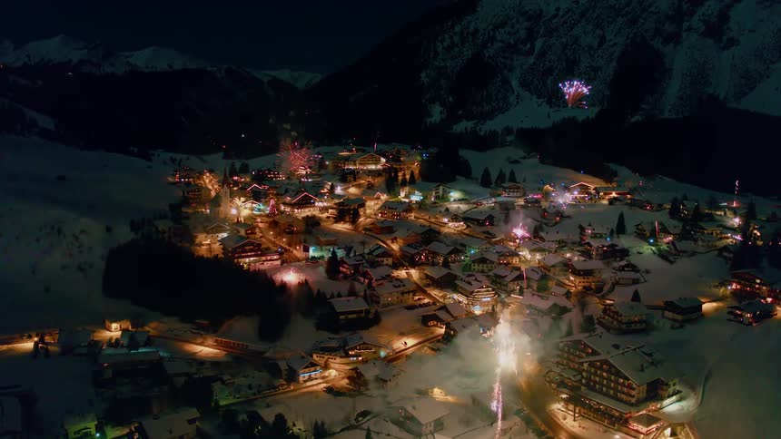 Fireworks go off over a snow covered village