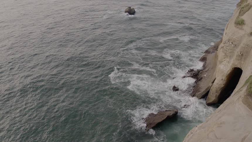 Ocean waves crash into a rocky shoreline
