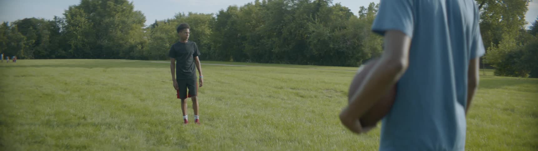 Two people stand on the field ready to play football