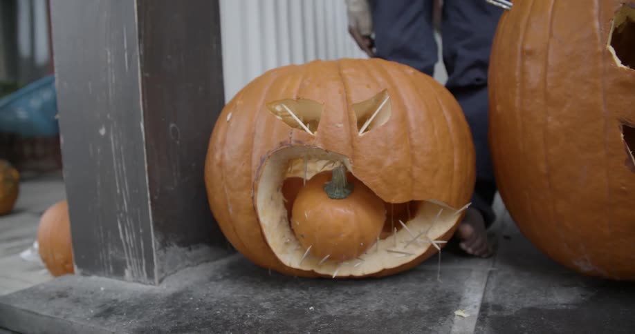Person arranging pumpkins outside